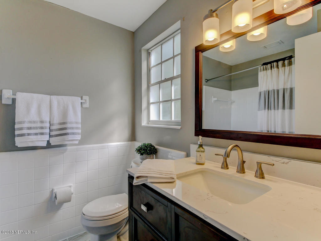 1041 Glen Echo Road Jacksonville, FL 32211 - Photo 23 of 40 a bathroom with a granite countertop sink a toilet and a mirror