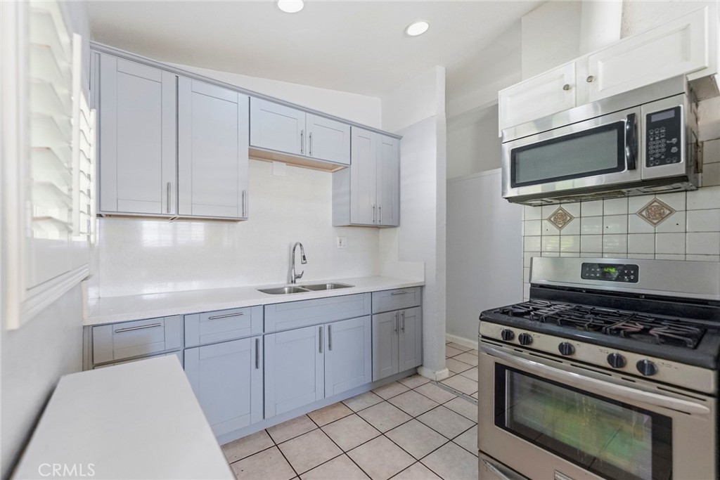 10363 Wagner Way Riverside, CA 92505 - Photo 9 of 26 a kitchen with stainless steel appliances a stove a microwave sink and cabinets