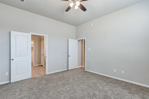 an empty room with chandelier fan