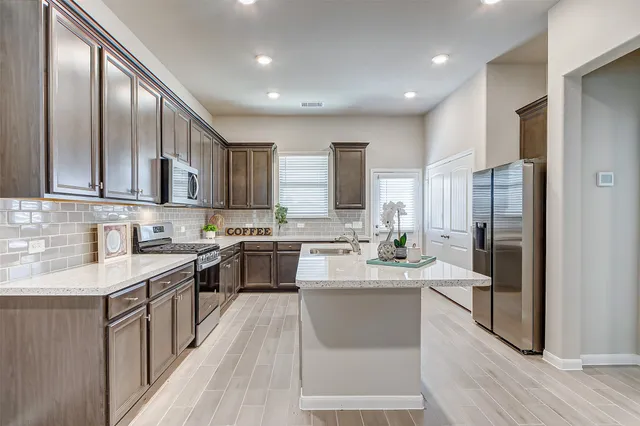 a large kitchen with stainless steel appliances lots of counter space and a sink