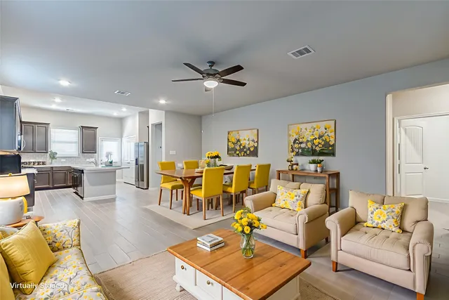 a living room with furniture kitchen view and a chandelier