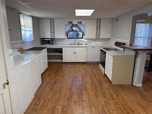a kitchen with a sink wooden floor and a stove
