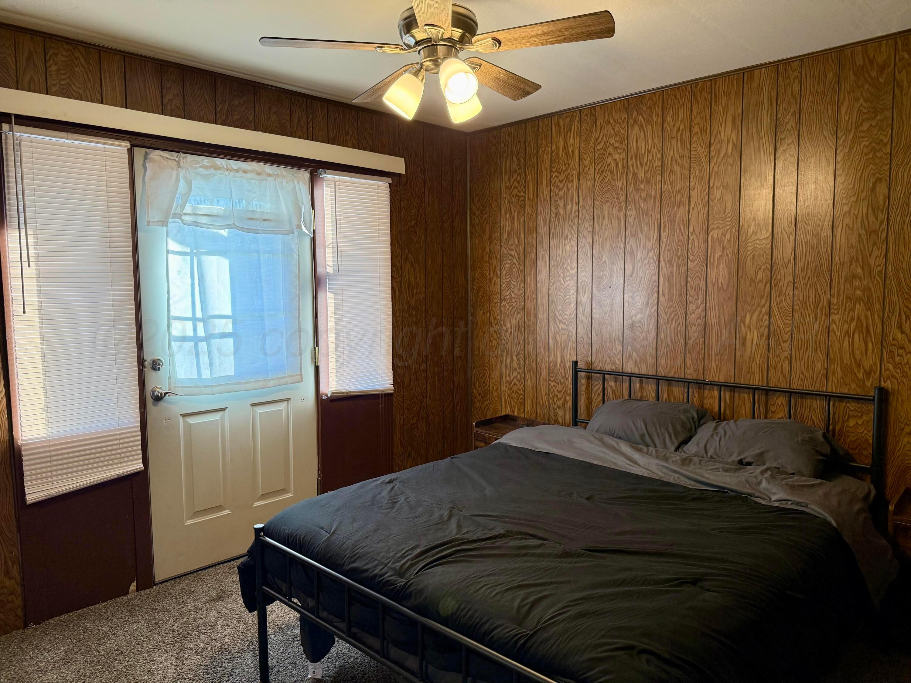 1405 Jennings Street Borger, TX 79007 - Photo 8 of 10 a bedroom with a bed and a chandelier