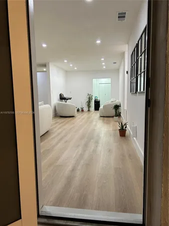 a view of a livingroom with furniture and a hallway