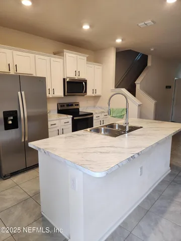 a kitchen with stainless steel appliances a refrigerator sink and microwave