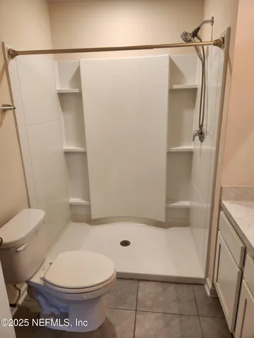 a bathroom with a toilet and a shower