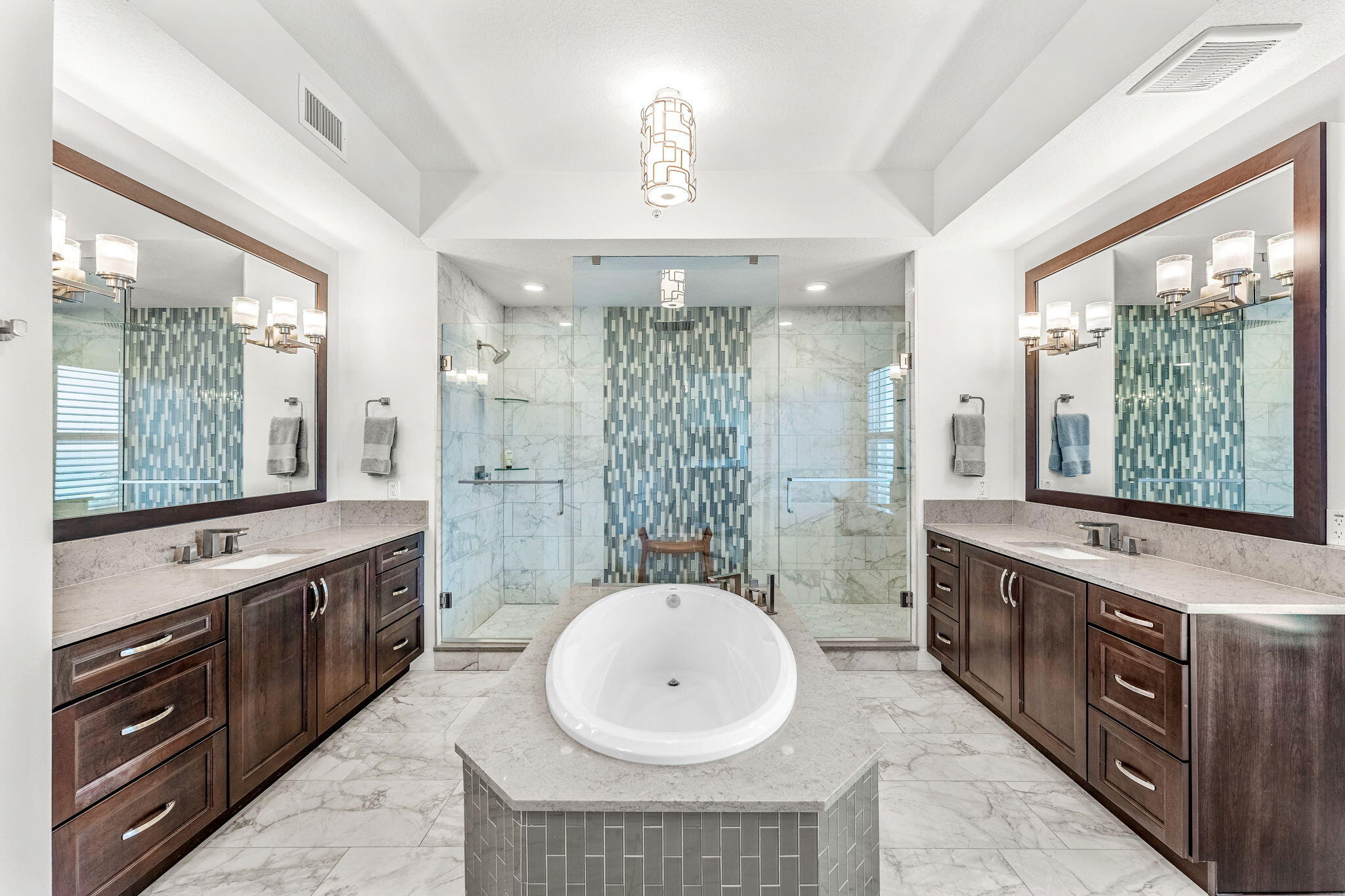 1725 North Hwy A1A, Unit 401 Indialantic, FL 32903 - Photo 14 of 39 a bathroom with a double vanity sink a large mirror and a bathtub with shower