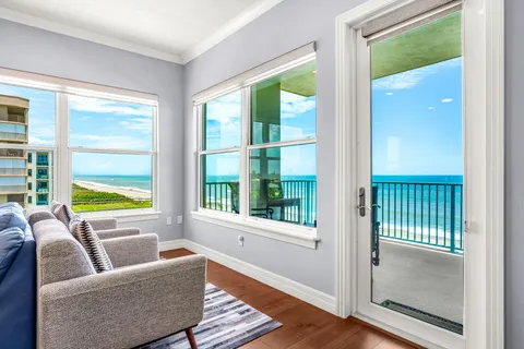 a living room with furniture kitchen view and a large window