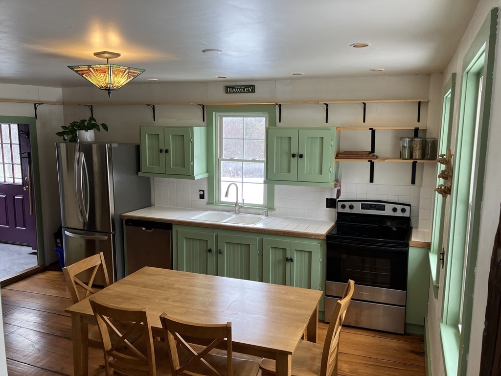 103 East Hawley Road Hawley, MA 01339 - Photo 14 of 34 a kitchen with a table chairs refrigerator and cabinets