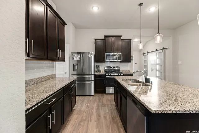 a kitchen with stainless steel appliances granite countertop a sink stove and refrigerator