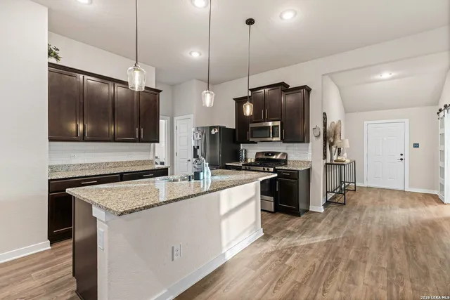 a kitchen with kitchen island a counter space a sink appliances and cabinets
