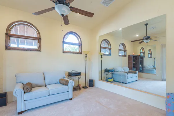 a living room with furniture a ceiling fan and a window