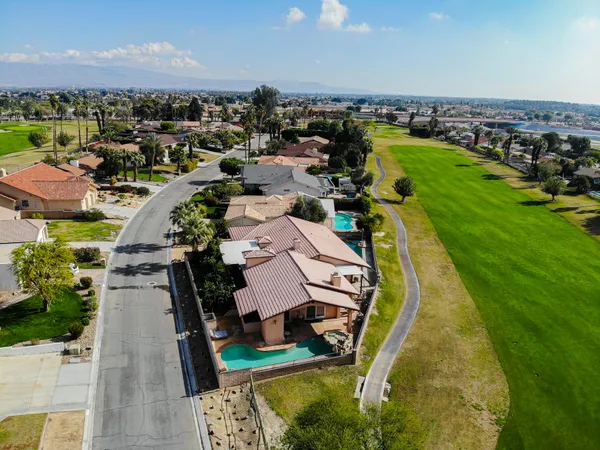 an aerial view of a house with a garden and lake view