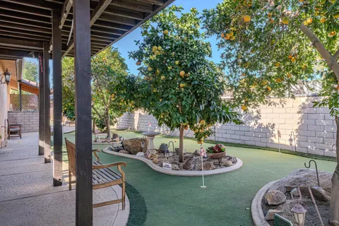 a view of a backyard with table and chairs potted plants and wooden fence