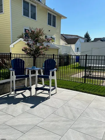 a view of a patio with table and chairs with wooden fence and plants
