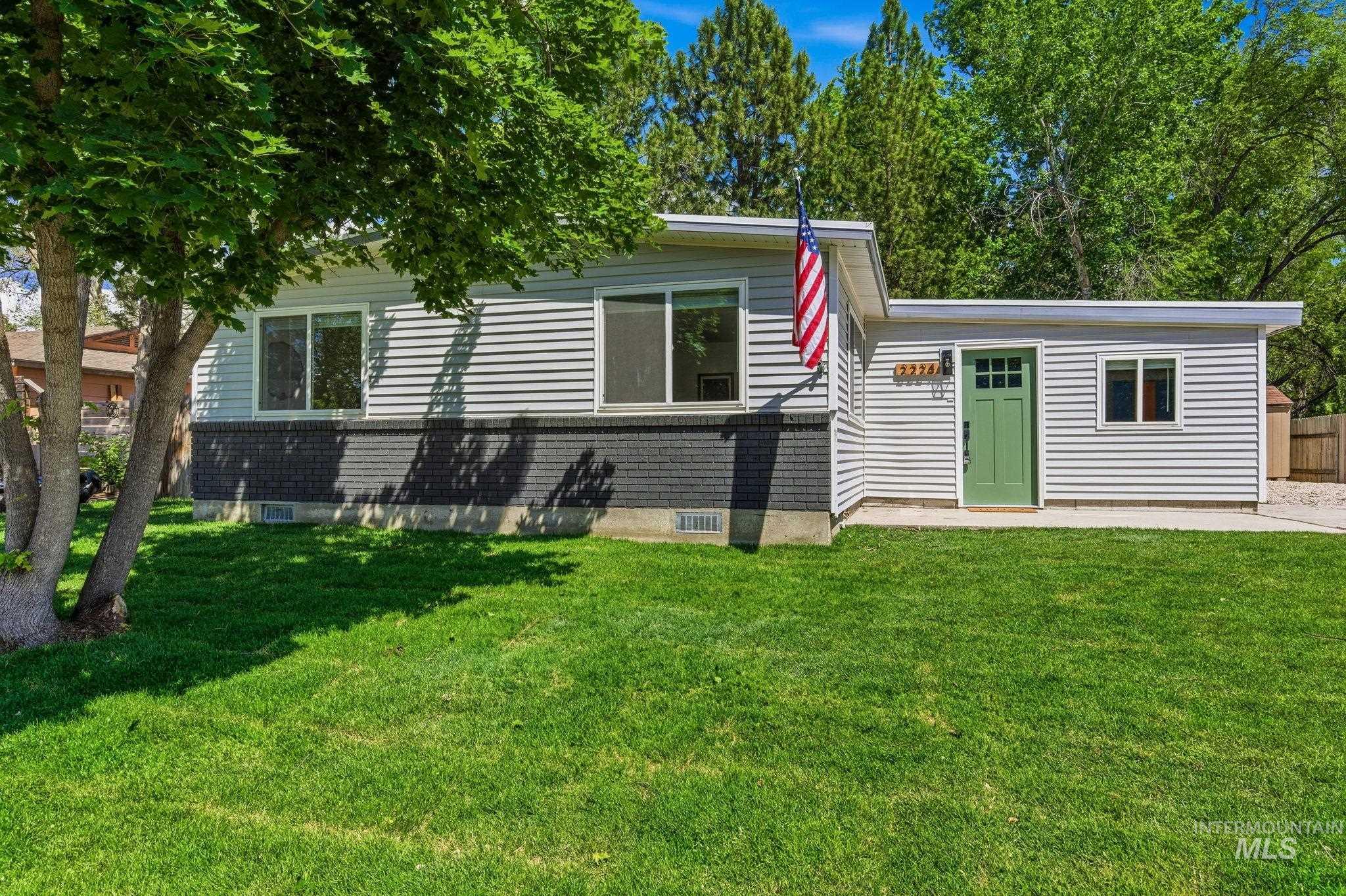 2224 Rachel Circle Boise, ID 83706 - Photo 5 of 50 Ranch-style exterior featuring light-colored horizontal siding, a dark brick foundation, and a vibrant green entry door