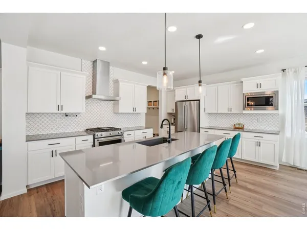 a kitchen with kitchen island granite countertop a sink a center island stainless steel appliances and cabinets