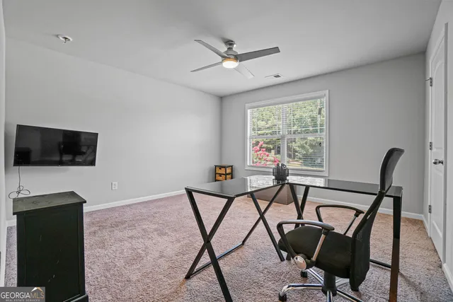 a view of a workspace with furniture and a window