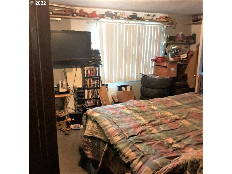 1223 Southeast Barnes Road Gresham, OR 97080 - Photo 6 of 12 a bedroom with a bed and large windows