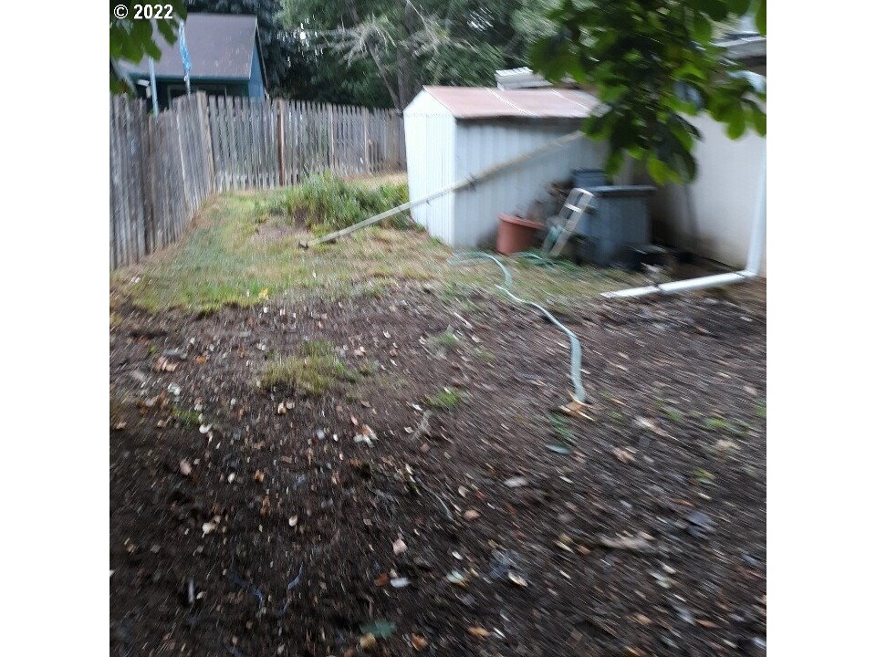 1223 Southeast Barnes Road Gresham, OR 97080 - Photo 10 of 12 a view of a backyard with plants and a fence
