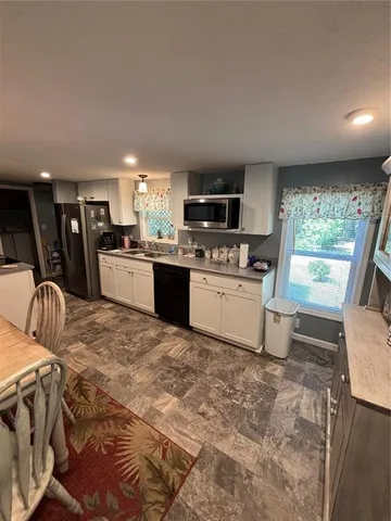 a kitchen with stainless steel appliances granite countertop a sink a stove a microwave a refrigerator a stove with island and chairs