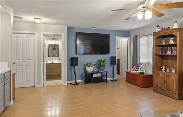 a view of a hallway to a livingroom with wooden floor and stairs