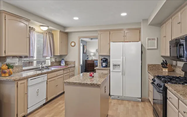 a kitchen with cabinets appliances a sink and a window