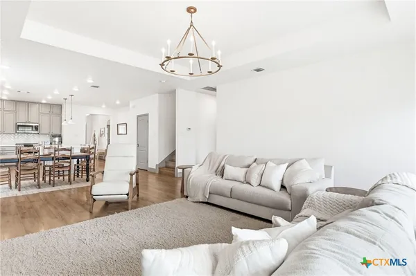 a living room with furniture and a chandelier