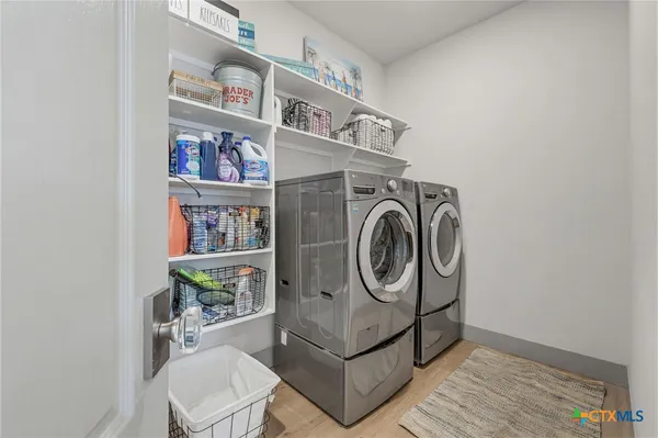 a living room with furniture a large window and a chandelier