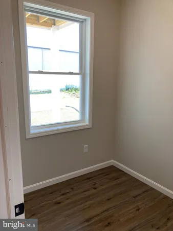 a view of a small space with wooden floor and a window