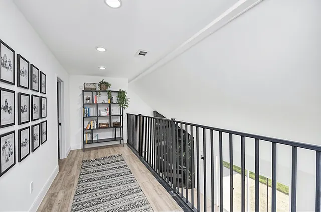 a view of a hallway with wooden floor and stairs