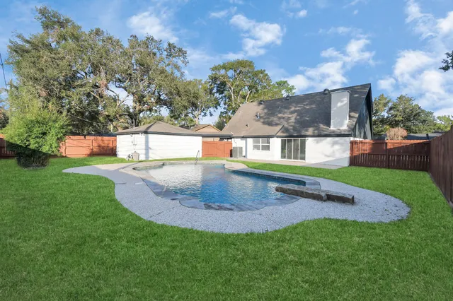 a swimming pool with outdoor seating and yard