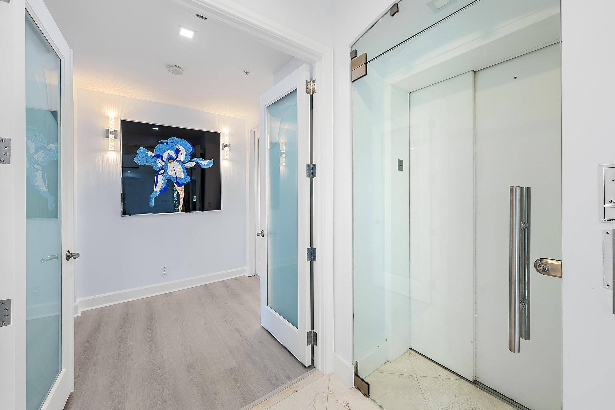 2070 North Ocean Boulevard, Unit PH4 Boca Raton, FL 33431 - Photo 21 of 46 a view of a hallway with wooden floor and paintings on the wall
