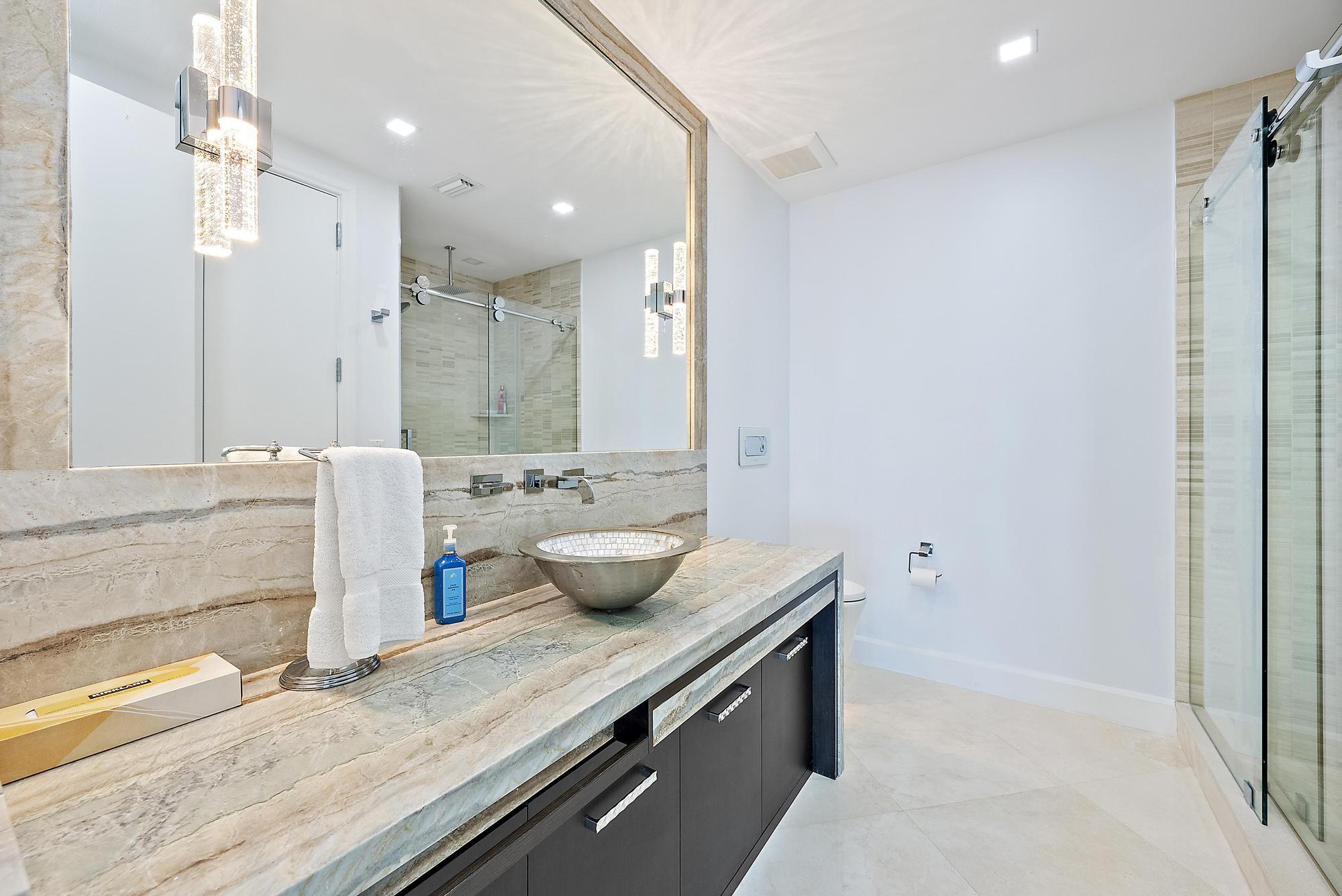 2070 North Ocean Boulevard, Unit PH4 Boca Raton, FL 33431 - Photo 35 of 46 a bathroom with a granite countertop sink a large mirror and shower
