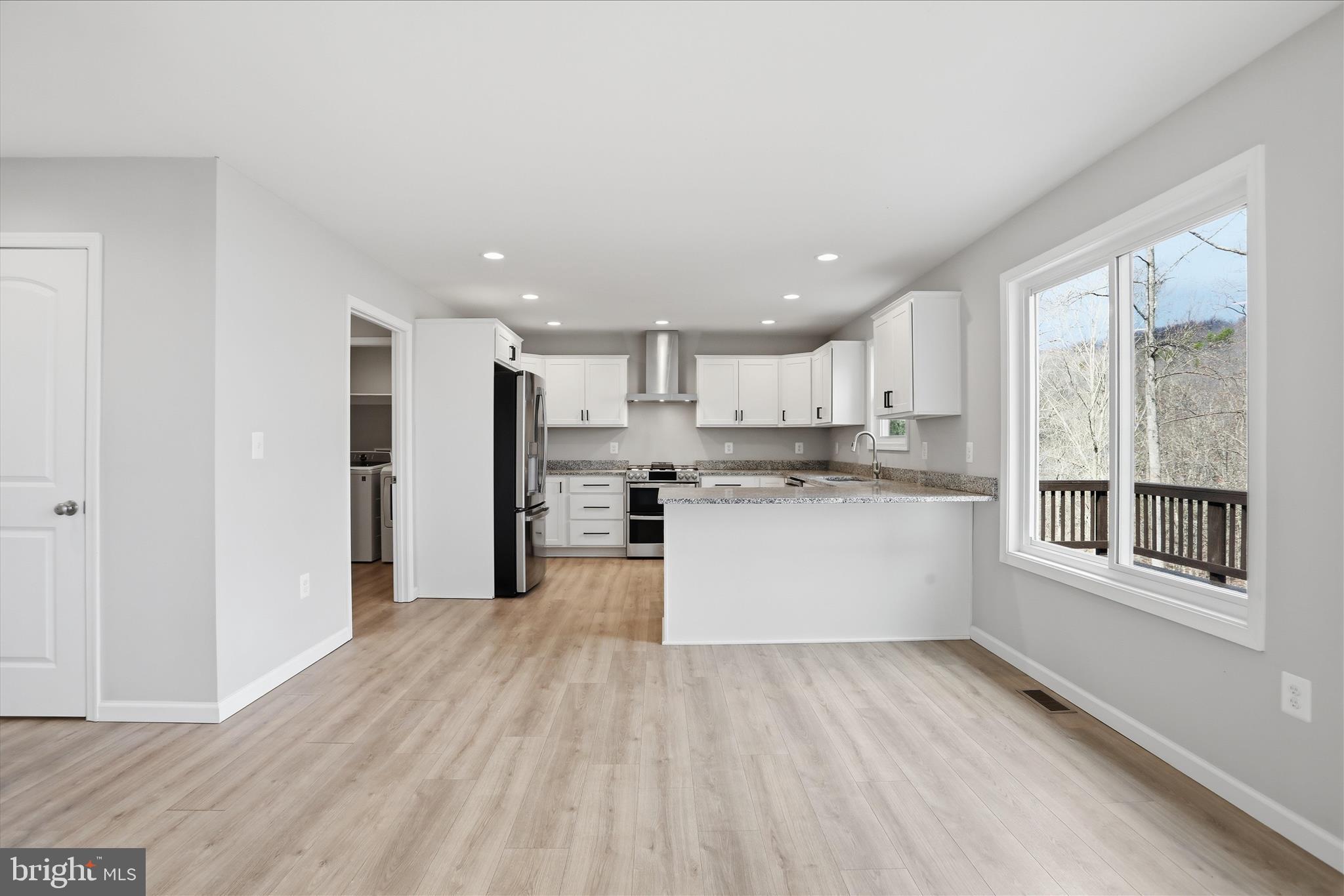 490 Black Twig Road Linden, VA 22642 - Photo 11 of 44 a large kitchen with stainless steel appliances kitchen island a large counter top and a wooden floors