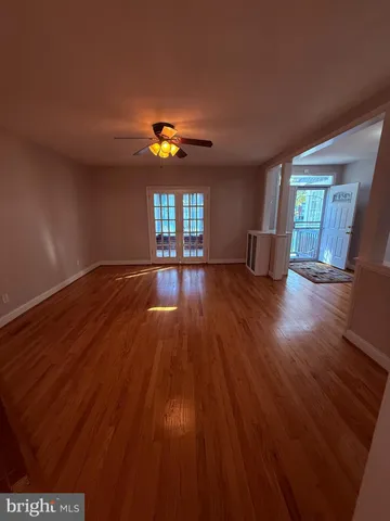 a view of an empty room with window and wooden floor