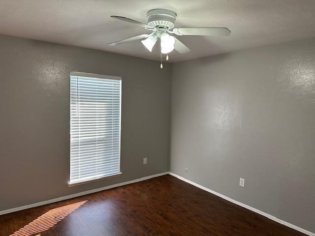 5500 Ragan Drive The Colony, TX 75056 - Photo 13 of 17 Spare room with a wealth of natural light, ceiling fan, baseboards, and wood finished floors