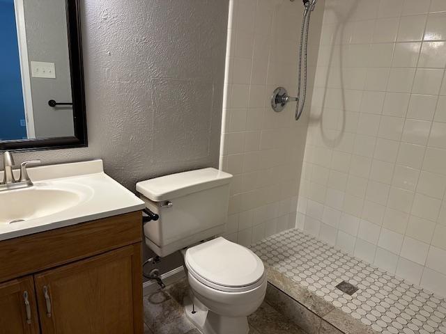 5500 Ragan Drive The Colony, TX 75056 - Photo 14 of 17 Full bathroom with a textured wall, vanity, toilet, and a shower stall
