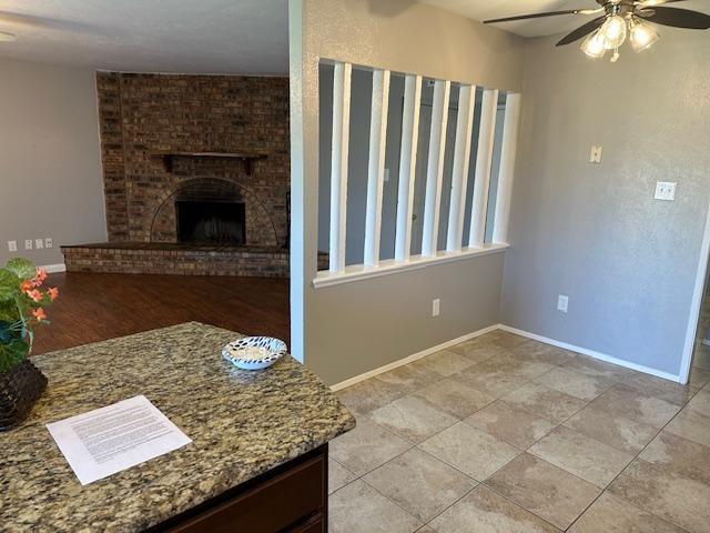 5500 Ragan Drive The Colony, TX 75056 - Photo 3 of 17 Unfurnished living room with a fireplace, baseboards, and a ceiling fan