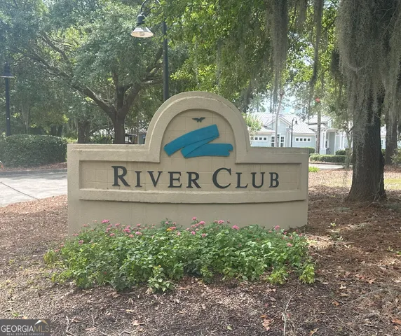 a view of a street sign under a large tree