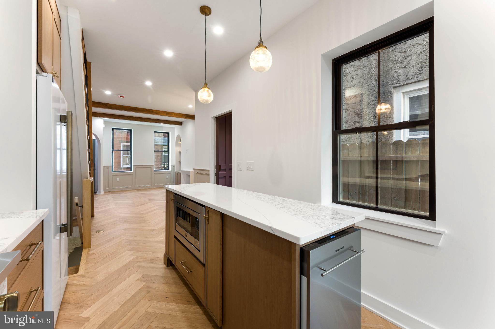 823 Mercer Street Philadelphia, PA 19125 - Photo 15 of 37 a kitchen with kitchen island a counter top space a sink stainless steel appliances and cabinets