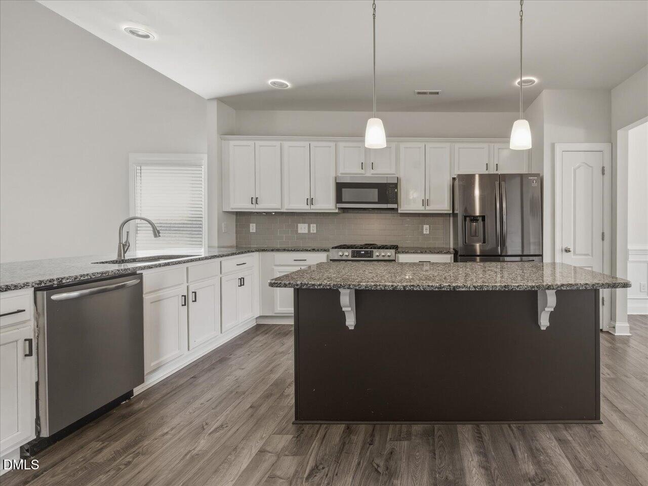 60 Pepper Lane Garner, NC 27529 - Photo 12 of 70 a kitchen with kitchen island granite countertop a sink cabinets and wooden floor