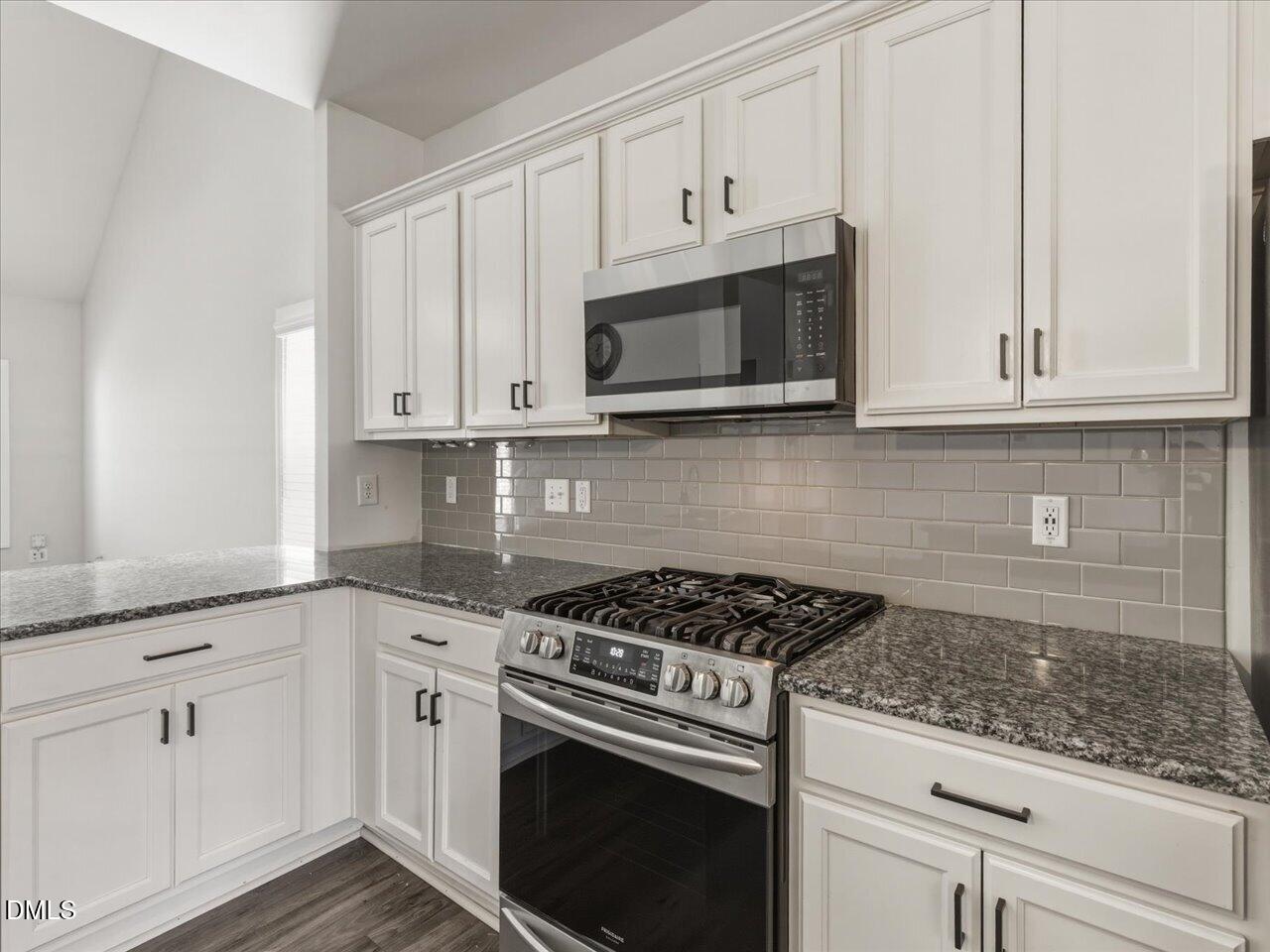 60 Pepper Lane Garner, NC 27529 - Photo 16 of 70 a kitchen with granite countertop white cabinets and stainless steel appliances