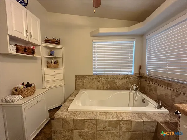 a bathroom with a tub sink and a window