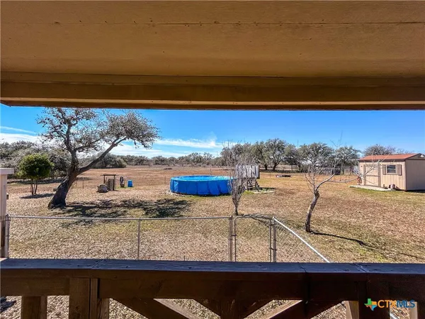 a view of a backyard with couches under an umbrella