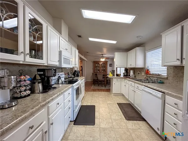 a large kitchen with stainless steel appliances lots of counter space and a sink