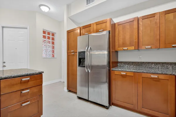 a kitchen with stainless steel appliances granite countertop a refrigerator and a cabinets
