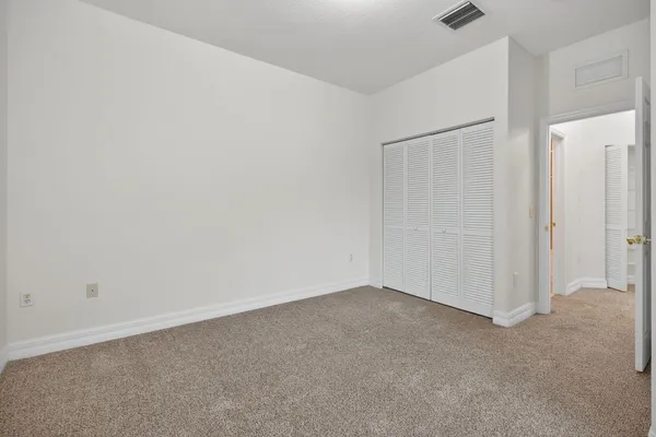 an empty room with wooden floor ceiling fan and windows