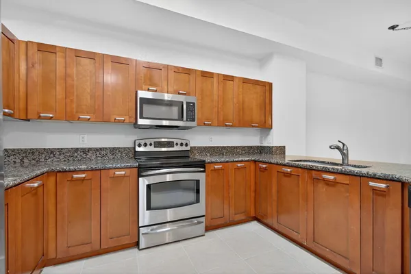 a kitchen with stainless steel appliances granite countertop a stove microwave and sink