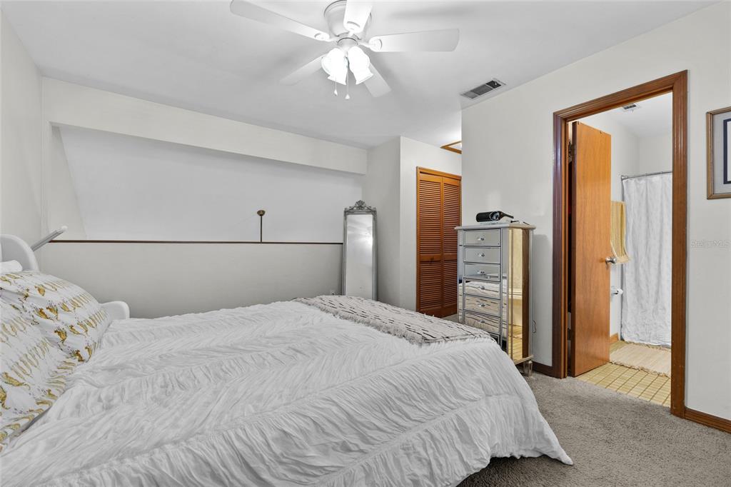 900 Southwest 62nd Boulevard, Unit L79 Gainesville, FL 32607 - Photo 11 of 24 a bedroom with a large bed and a chandelier